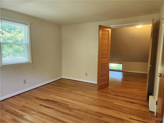 70 W Elizabeth St, Skaneateles, NY 13152 - empty room featuring wood finished floors, healthy amount of natural light, and a baseboard heating unit