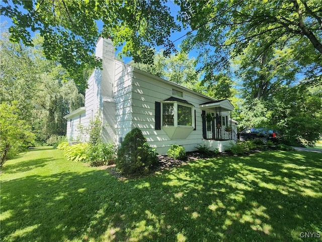 70 W Elizabeth St, Skaneateles, NY 13152 - view of property exterior with a lawn and a chimney