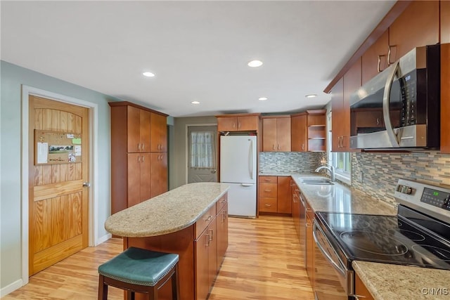 8278 Maple Rd, Clay, NY 13041 - kitchen featuring appliances with stainless steel finishes, light wood-style floors, backsplash, a center island, and recessed lighting