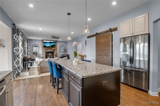 123 Stonebridge Rd, Grand Island, NY 14072 - kitchen with stainless steel appliances, a barn door, recessed lighting, ceiling fan, and wood finished floors