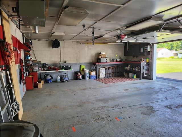313 Gardner Rd, Horseheads, NY 14845 - garage with a workshop area, a garage door opener, and concrete block wall