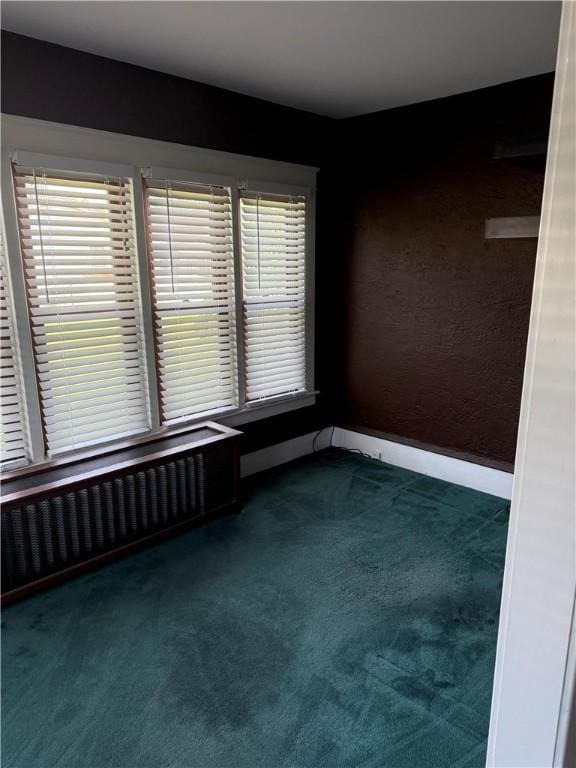 16 Cobbles E, Elmira, NY 14905 - unfurnished room with dark carpet, radiator, and baseboards
