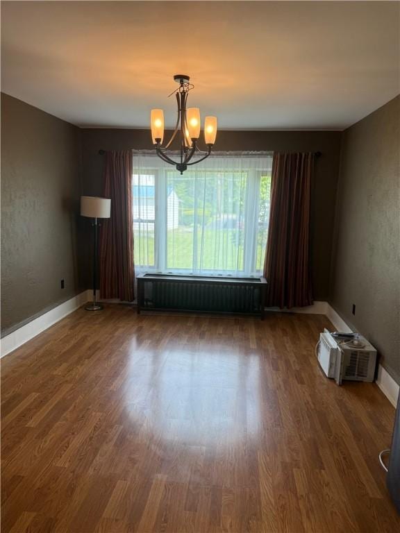 16 Cobbles E, Elmira, NY 14905 - unfurnished room with radiator heating unit, plenty of natural light, a chandelier, and wood finished floors