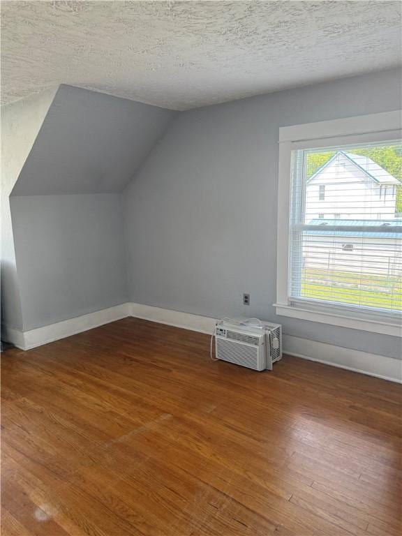 16 Cobbles E, Elmira, NY 14905 - bonus room featuring lofted ceiling, wood finished floors, baseboards, a wall unit AC, and a textured ceiling
