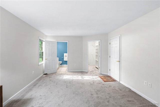 1 Wicklow Dr, Skaneateles, NY 13152 - unfurnished bedroom featuring light colored carpet, baseboards, a walk in closet, connected bathroom, and a closet