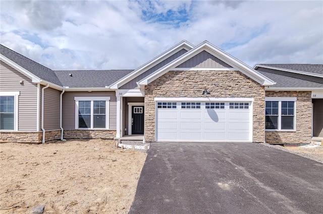 56 Cedarway Cir, Webster, NY 14580 - view of front of home featuring stone siding, asphalt driveway, an attached garage, and board and batten siding