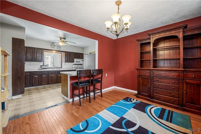 172 Nichols Ave, Syracuse, NY 13206 - dining space with a chandelier, light wood-style flooring, baseboards, and ceiling fan