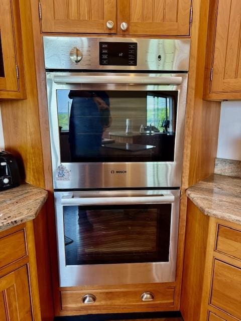 251 Pearsall Rd, Westford, NY 12155 - kitchen featuring stainless steel double oven, brown cabinetry, and light stone countertops