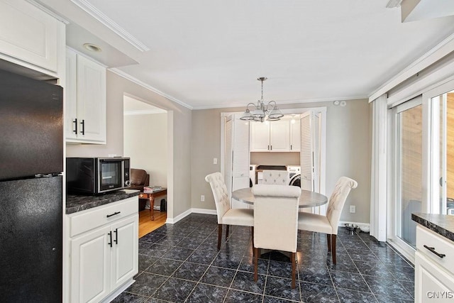 4190 Stepping Stone Ln, Clay, NY 13090 - dining space featuring a chandelier, crown molding, dark tile patterned flooring, baseboards, and washer / clothes dryer