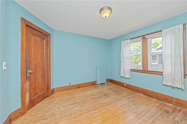 1579 Culver Rd, Rochester, NY 14609 - spare room featuring radiator heating unit, wood finished floors, and baseboards