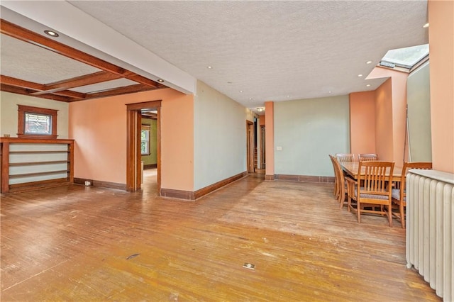 1579 Culver Rd, Rochester, NY 14609 - unfurnished room featuring radiator heating unit, hardwood / wood-style flooring, a textured ceiling, baseboards, and plenty of natural light