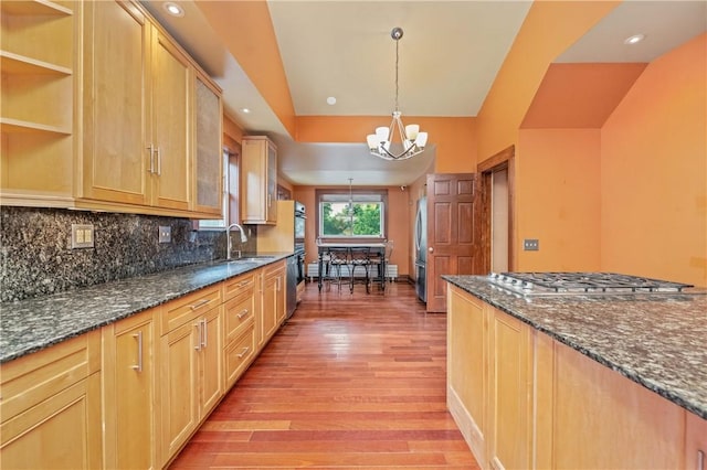 1579 Culver Rd, Rochester, NY 14609 - kitchen with light wood-style flooring, stainless steel appliances, a sink, a chandelier, and dark stone countertops