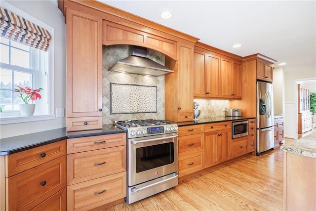 2 Princeton Ln, Perinton, NY 14450 - kitchen featuring appliances with stainless steel finishes, wall chimney range hood, light wood-style flooring, backsplash, and recessed lighting