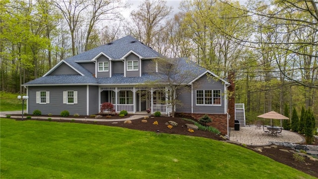 256 Queen Esther Dr, Sayre, PA 18840 - view of front of house featuring a porch, a front yard, a chimney, roof with shingles, and brick siding