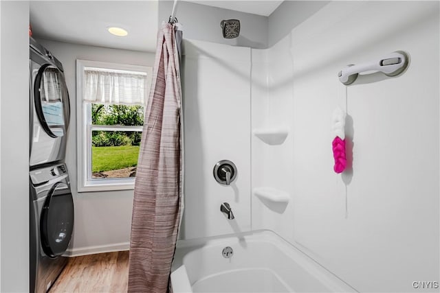 3838 Dawes Ave, Kirkland, NY 13323 - bathroom with stacked washer and clothes dryer, shower / tub combo with curtain, wood finished floors, and baseboards