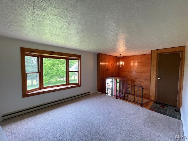 465 Blanding Rd, Sherburne, NY 13460 - unfurnished room with a baseboard heating unit, wood walls, a chandelier, a textured ceiling, and baseboards