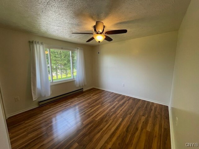 465 Blanding Rd, Sherburne, NY 13460 - spare room featuring a baseboard heating unit, dark wood-style flooring, a textured ceiling, a ceiling fan, and baseboards