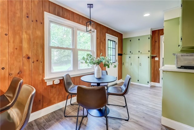 12 Edgewood Dr, Penfield, NY 14526 - dining area featuring baseboards, light wood-style floors, and wood walls