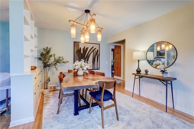 12 Edgewood Dr, Penfield, NY 14526 - dining area with a chandelier, light wood-style flooring, and baseboards