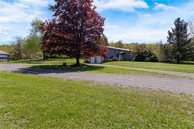 5750 Sentinel Heights Rd, Onondaga, NY 13078 - view of green lawn with a garage and dirt driveway