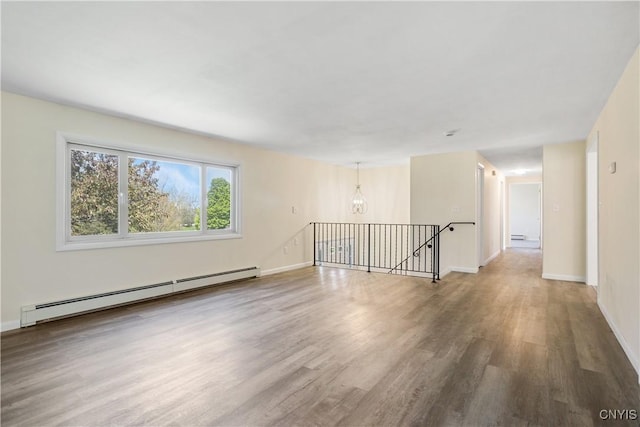 5750 Sentinel Heights Rd, Onondaga, NY 13078 - unfurnished room featuring a baseboard radiator, wood finished floors, baseboards, and a chandelier