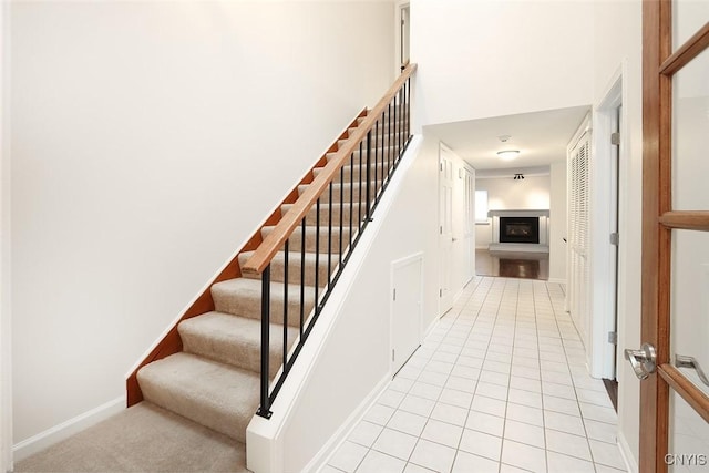 442 Summerhaven Dr N, Manlius, NY 13057 - stairway with a glass covered fireplace, tile patterned flooring, and baseboards