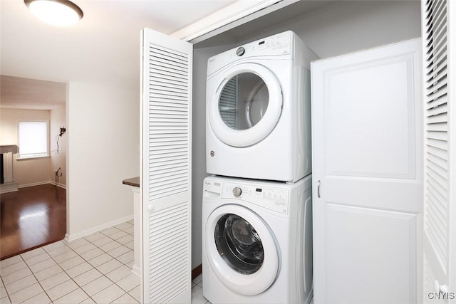 442 Summerhaven Dr N, Manlius, NY 13057 - laundry area with stacked washer / dryer, light tile patterned floors, and baseboards