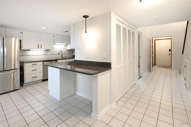 442 Summerhaven Dr N, Manlius, NY 13057 - kitchen with stainless steel appliances, light tile patterned floors, a sink, a peninsula, and tasteful backsplash