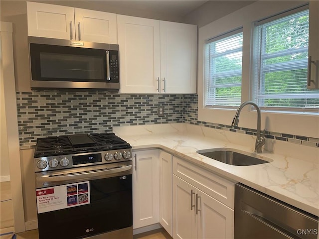 530 Lenox Ave, Oneida, NY 13421 - kitchen featuring stainless steel appliances, white cabinetry, decorative backsplash, and light stone countertops