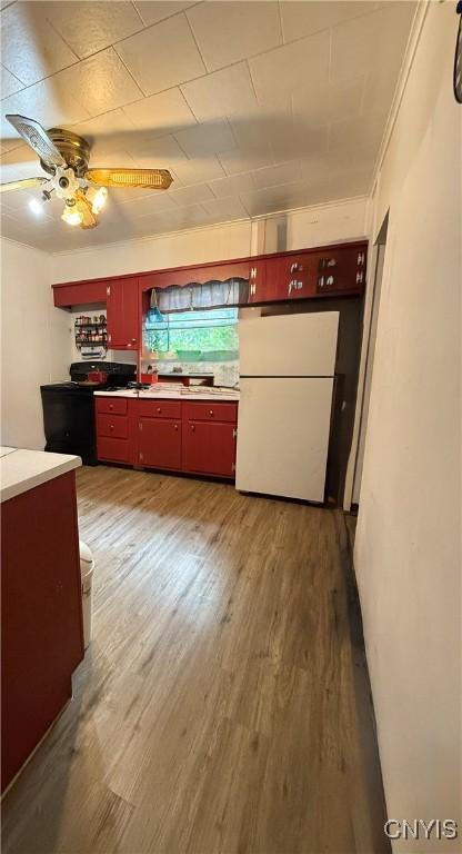 214-16 Reed Ave, Syracuse, NY 13207 - kitchen with freestanding refrigerator, red cabinets, a ceiling fan, and wood finished floors