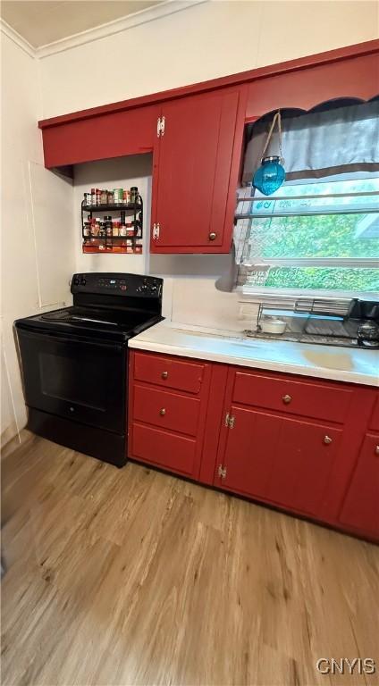 214-16 Reed Ave, Syracuse, NY 13207 - kitchen with black range with electric stovetop, light wood finished floors, ornamental molding, red cabinets, and light countertops