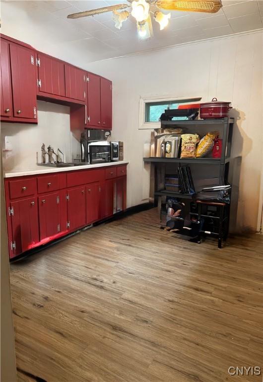 214-16 Reed Ave, Syracuse, NY 13207 - kitchen featuring red cabinets, a ceiling fan, and wood finished floors