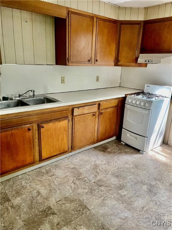214-16 Reed Ave, Syracuse, NY 13207 - kitchen featuring white gas stove, exhaust hood, and brown cabinetry