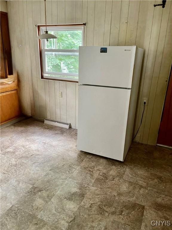 214-16 Reed Ave, Syracuse, NY 13207 - kitchen featuring freestanding refrigerator, baseboard heating, wooden walls, and stone finish floors