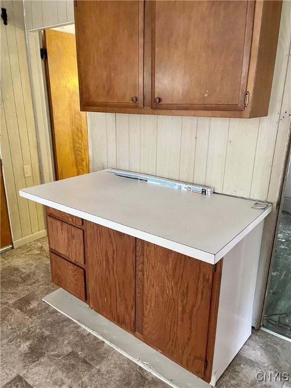 214-16 Reed Ave, Syracuse, NY 13207 - kitchen with wood walls, brown cabinets, and light countertops