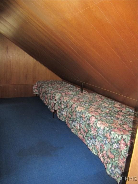 250 Pine Grove Rd Unit 3, Richland, NY 13142 - bedroom with dark colored carpet, wooden ceiling, wood walls, and lofted ceiling