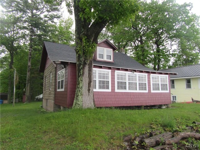 250 Pine Grove Rd Unit 3, Richland, NY 13142 - view of side of home with a shingled roof, a lawn, and a chimney