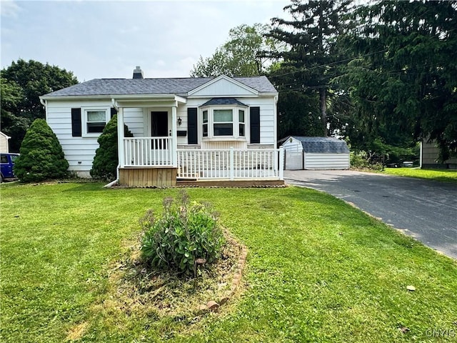 104 Lansdale Rd, Dewitt, NY 13057 - bungalow with an outbuilding, a front yard, a chimney, covered porch, and a shingled roof