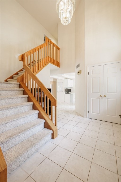 204 Red Hickory Dr, Greece, NY 14626 - staircase featuring a high ceiling, tile patterned floors, and a chandelier