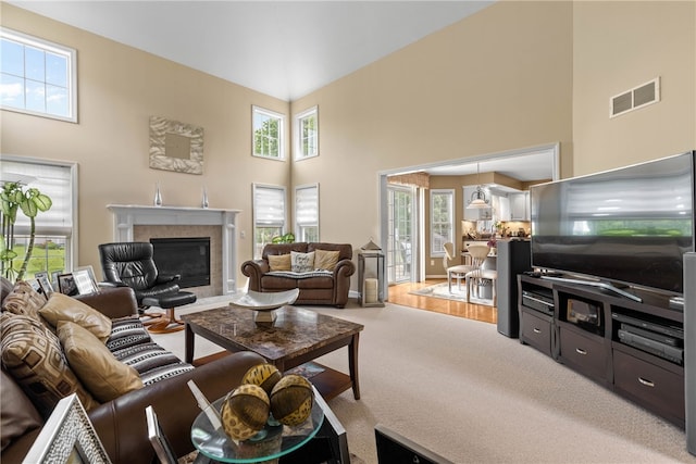 854 Park Haven Dr, Webster, NY 14580 - carpeted living area featuring a towering ceiling, healthy amount of natural light, and a glass covered fireplace