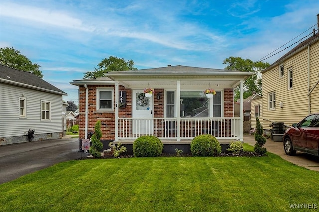 157 73rd St, Niagara Falls, NY 14304 - view of front of house with brick siding, covered porch, and a front lawn