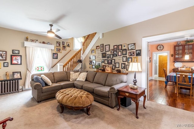 57 Savage Pl, Aurora, NY 14052 - carpeted living room featuring stairway, ceiling fan, radiator heating unit, and wood finished floors