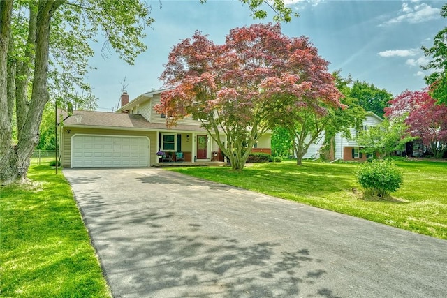 54 Hillary Dr, Chili, NY 14624 - view of property hidden behind natural elements featuring asphalt driveway, an attached garage, a front lawn, and a chimney