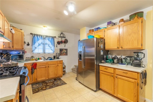 286 Troup St, Rochester, NY 14608 - kitchen with stainless steel appliances, light countertops, a sink, light floors, and under cabinet range hood