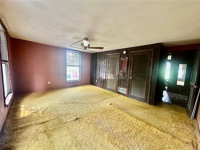 2095 Turnpike Rd, Throop, NY 13021 - unfurnished bedroom with carpet floors, wallpapered walls, a ceiling fan, and an accent wall