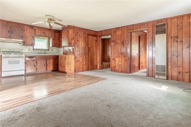 149 Centre St, Cape Vincent, NY 13618 - kitchen with white range with gas stovetop, a heating unit, brown cabinets, a ceiling fan, and under cabinet range hood