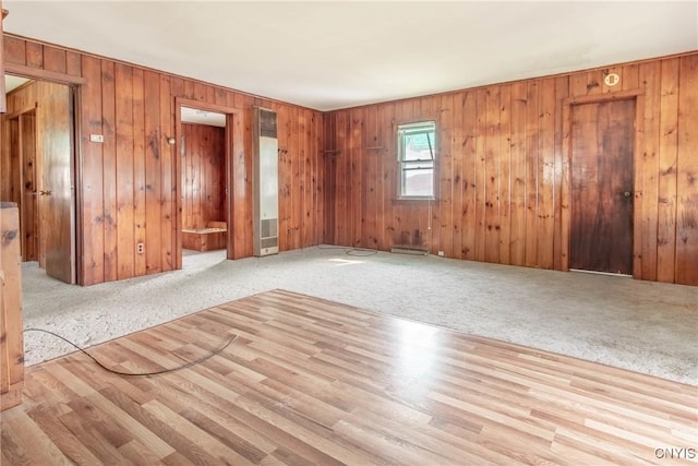149 Centre St, Cape Vincent, NY 13618 - empty room with a heating unit, carpet, baseboard heating, and wooden walls
