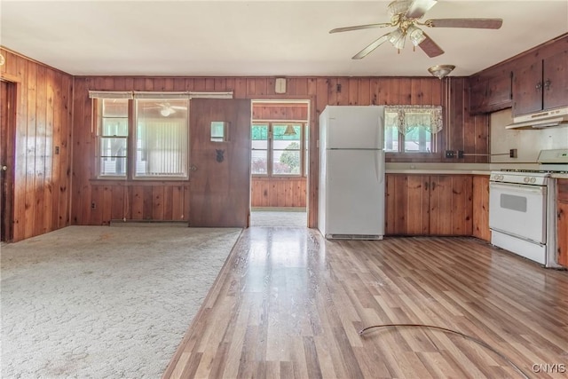149 Centre St, Cape Vincent, NY 13618 - kitchen featuring white appliances, under cabinet range hood, a ceiling fan, wooden walls, and light countertops