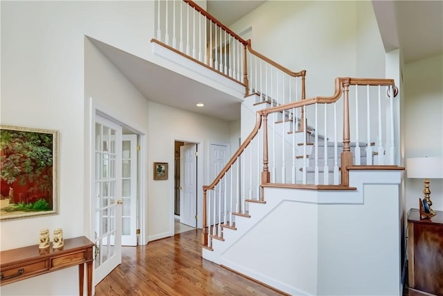 863 Rolins Run, Webster, NY 14580 - staircase featuring wood finished floors, french doors, a high ceiling, baseboards, and recessed lighting
