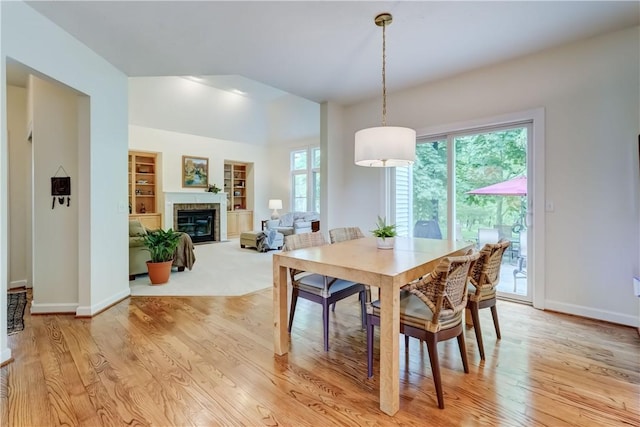 863 Rolins Run, Webster, NY 14580 - dining room with light wood-style floors, baseboards, a glass covered fireplace, and built in shelves